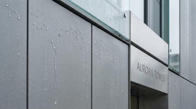 Close-up of a modern building facade with innovative surface protection and water droplets beading off.