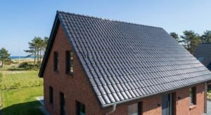A professionally cleaned and coated roof on a modern brick house in Kiel under a clear blue sky.