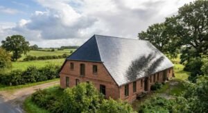 A professional weatherproof roof coating on a traditional house in Schleswig-Holstein under a clearing sky.